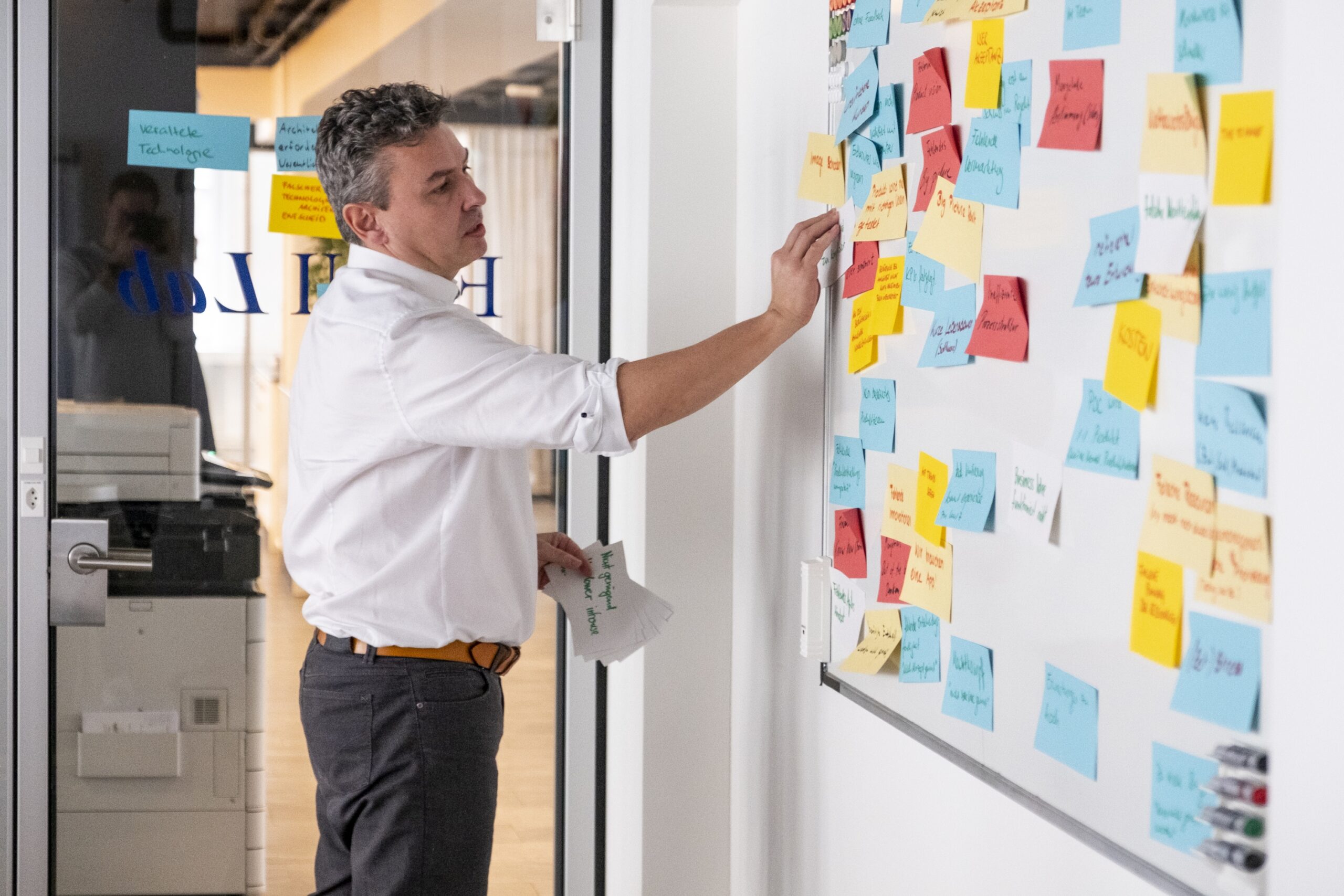 business analyst in front of a board with post-its considering using ai for enhancing his processes