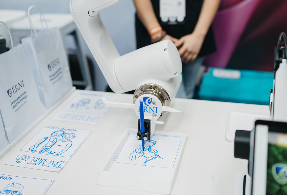 Robotic arm drawing with a pencil to illustrate physical AI in industrial production